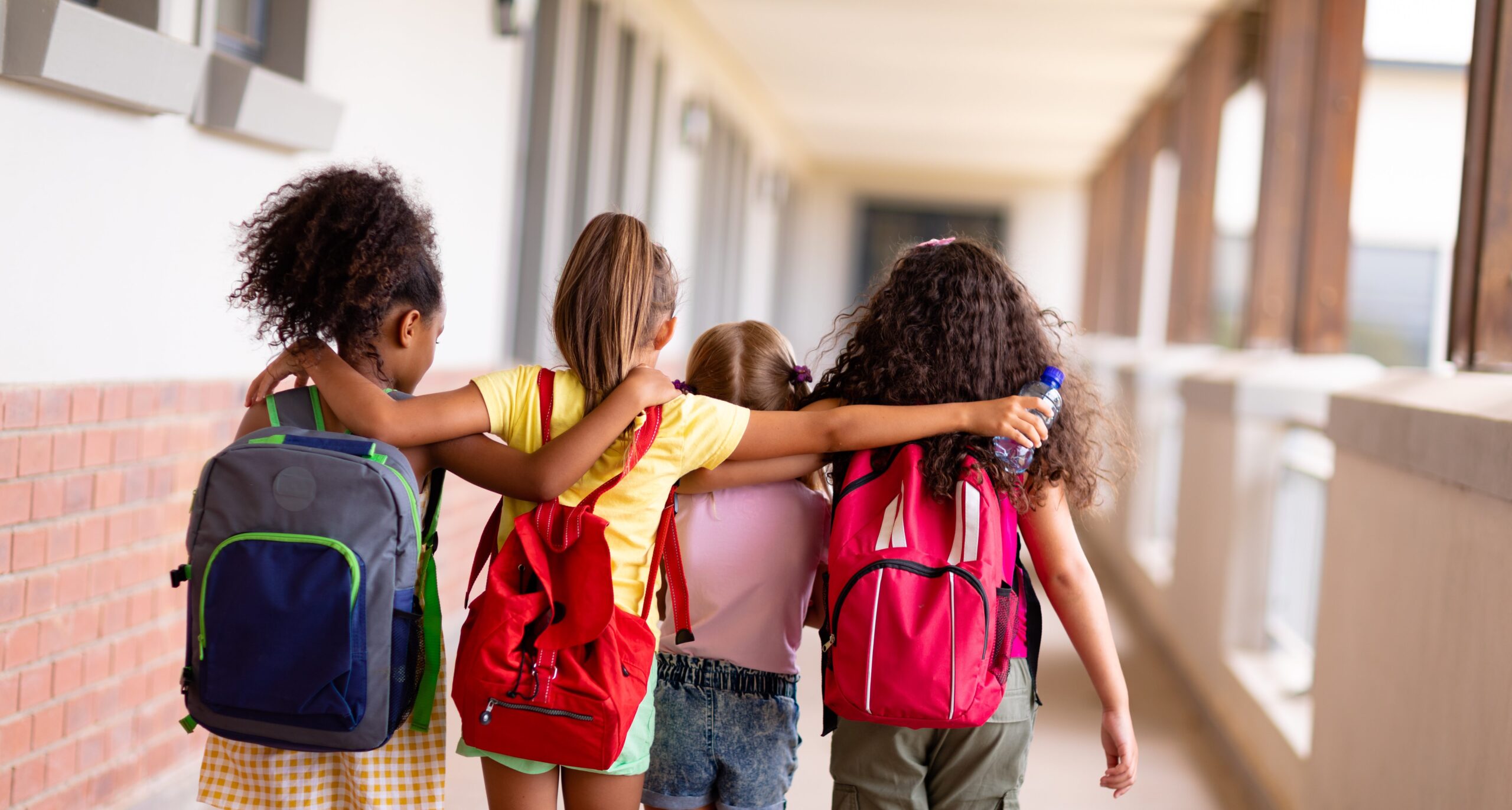 Kinder in der Grundschule mit Rucksäcken