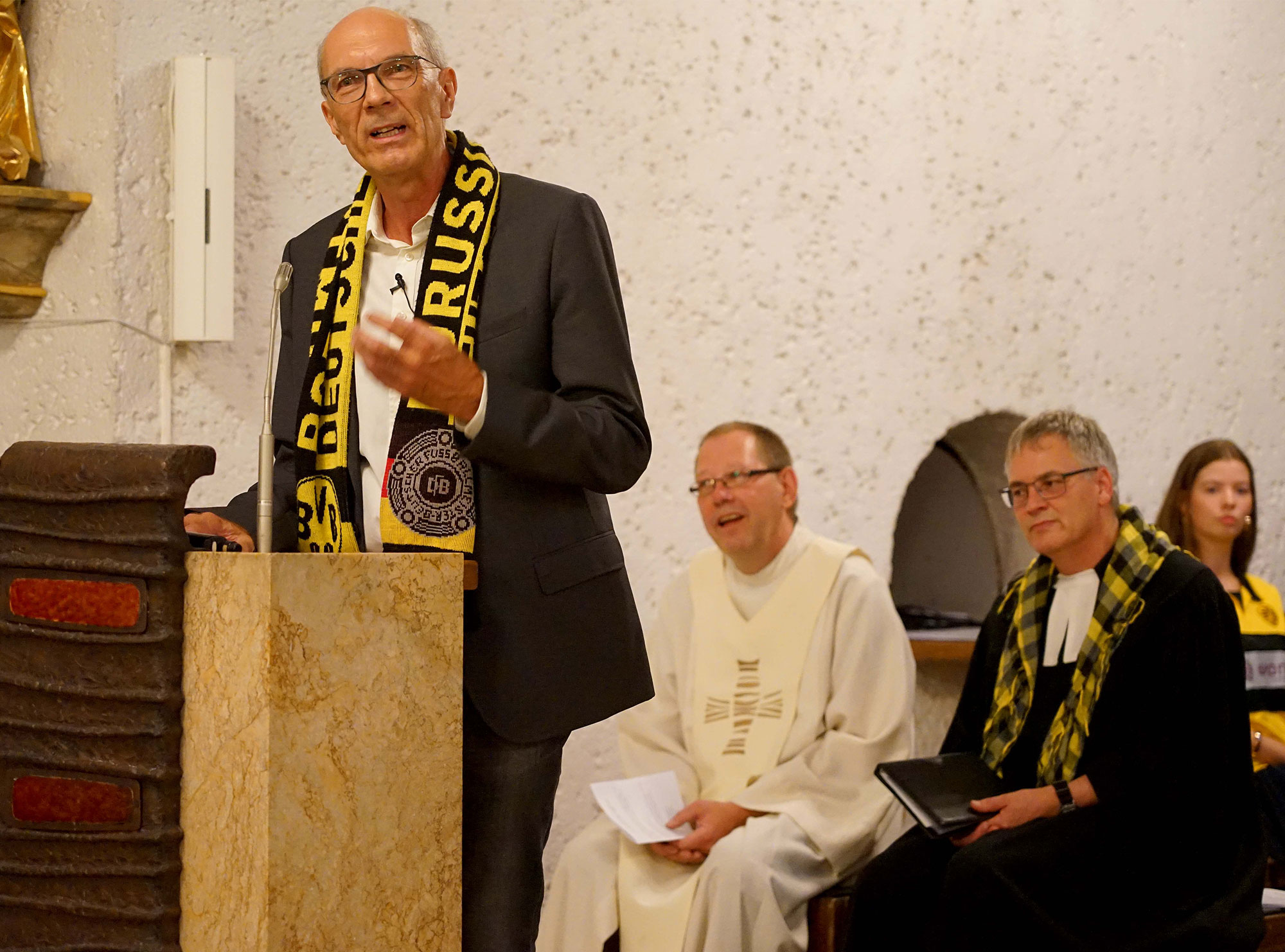 Der Journalist und Autor Kay Bandermann (links) predigte beim ökumenischen Gottesdienst zum Saisonauftakt in der BVB-Gründerkirche, der Dreifaltigkeitskirche in Dortmund. Im Hintergrund: Gemeindereferent Karsten Haug und Pfarrer Rüdiger Holthoff (v.l.). Foto: Michael Bodin / Erzbistum Paderborn