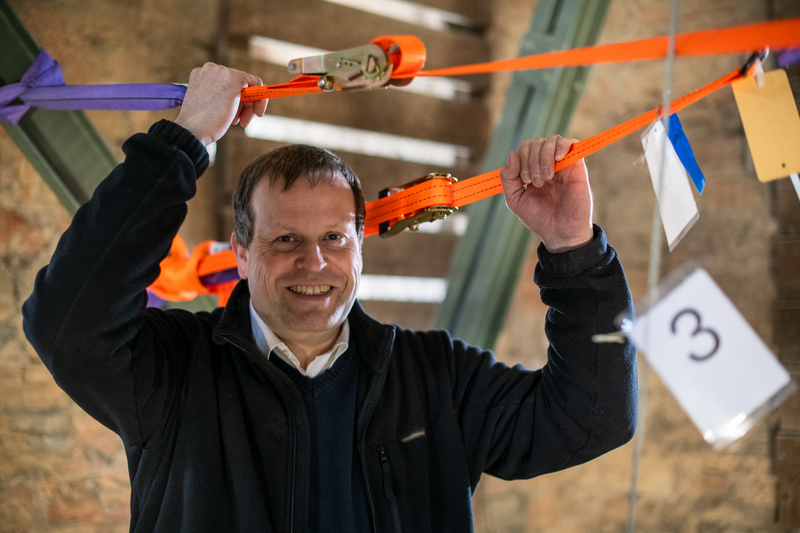 Pastor Martin Hufelschulte steht im Glockenstuhl des Paderborner Domes, um die Glocken für das Beiern manuell anzuschlagen.